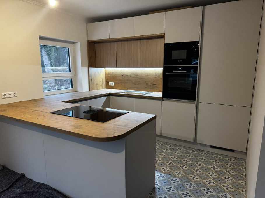 Helle U-Form-Küche mit Holz-Rückwand – von System & Idee geplant und montiert