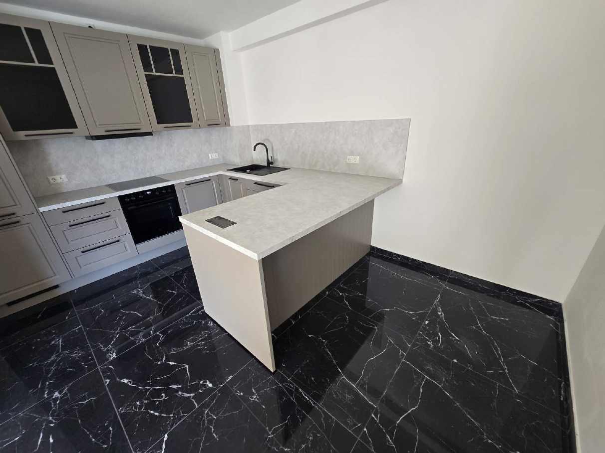 Shaker-Küche in Taupe mit Halbinsel und Marmor-Arbeitsplatte, montiert von System und Idee