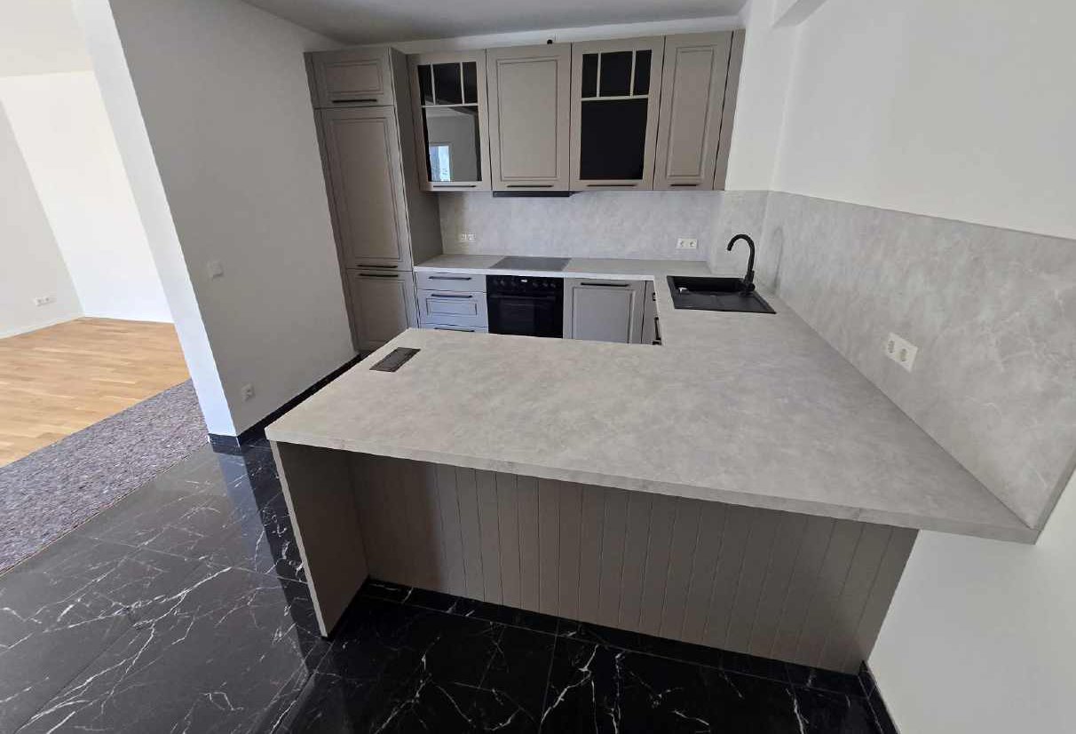 U-Küche mit Shaker-Fronten in Taupe und Marmor-Dekor, montiert von System und Idee